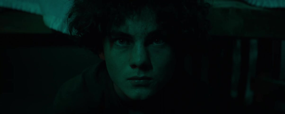 Portrait of a man in a dark room with a hateful facial expression