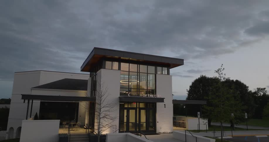 Modern building surrounded by vegetation of a church building on a cloudy day