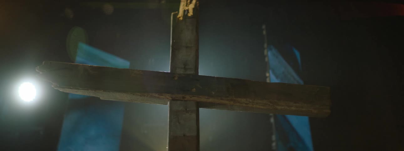 Wooden cross highlighted by lights on a stage