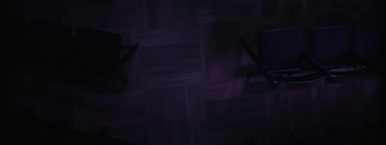 Chairs arranged in a line in a dark auditorium