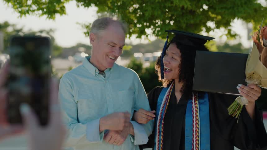 A graduate is celebrating with her diploma in hand