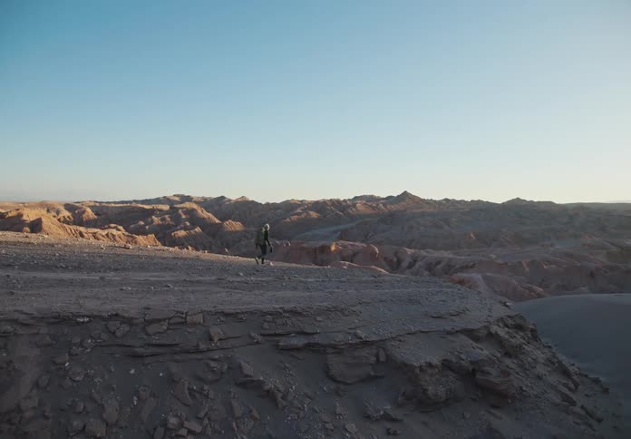 Rocky mountains and desert with a person walking