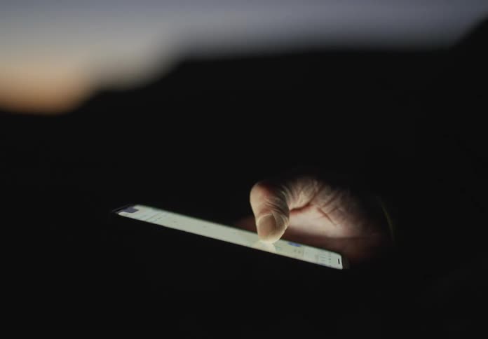 Closeup on hand using a smartphone in a natural environment