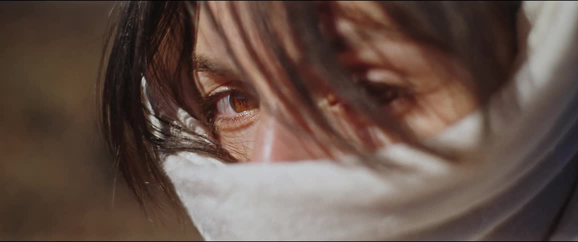 Portrait of a young womans face with a scarf covering her face and her eyes visible