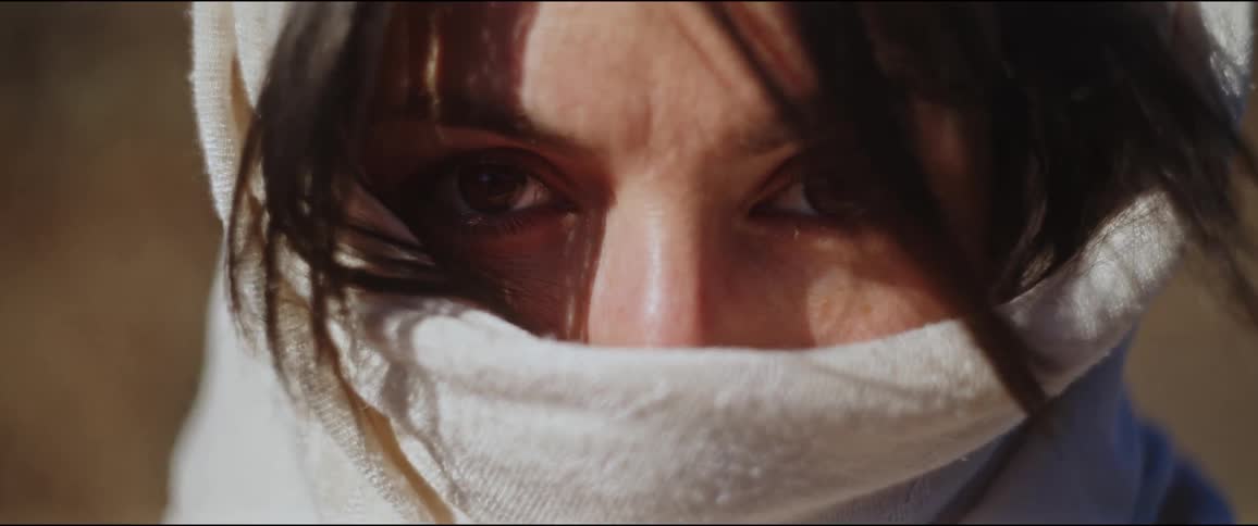 A woman has her face covered in a shawl