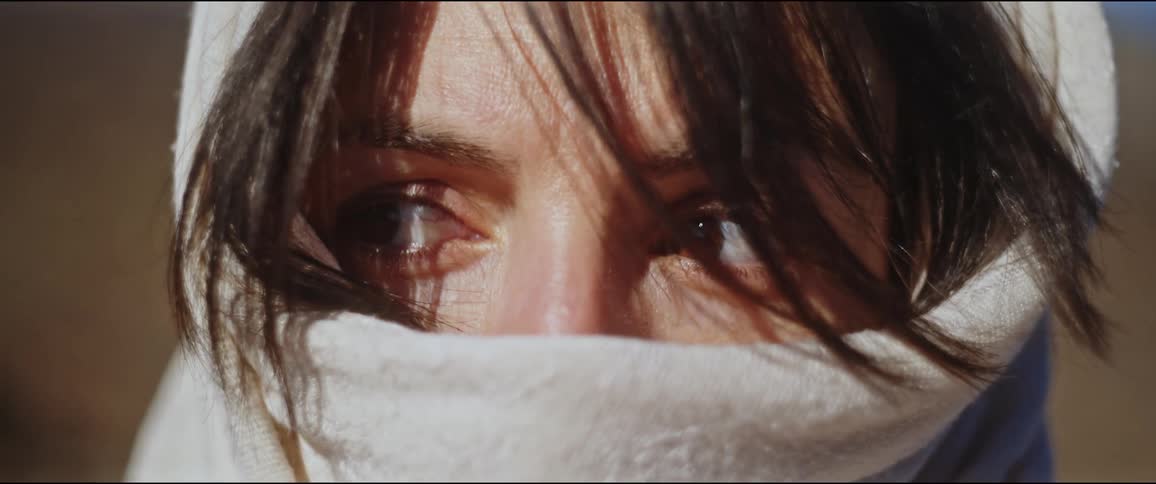 Close up of the face of a woman wearing a scarf over her head