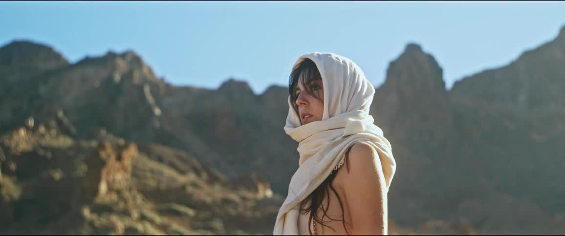 Woman with a scarf on her head in a natural environment with mountains around