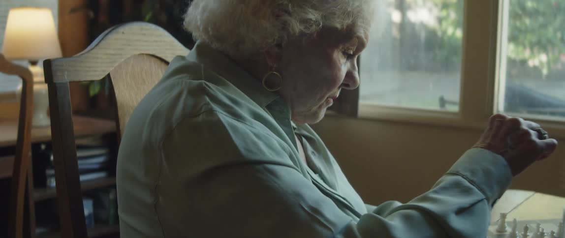 Woman considers which chess piece to move