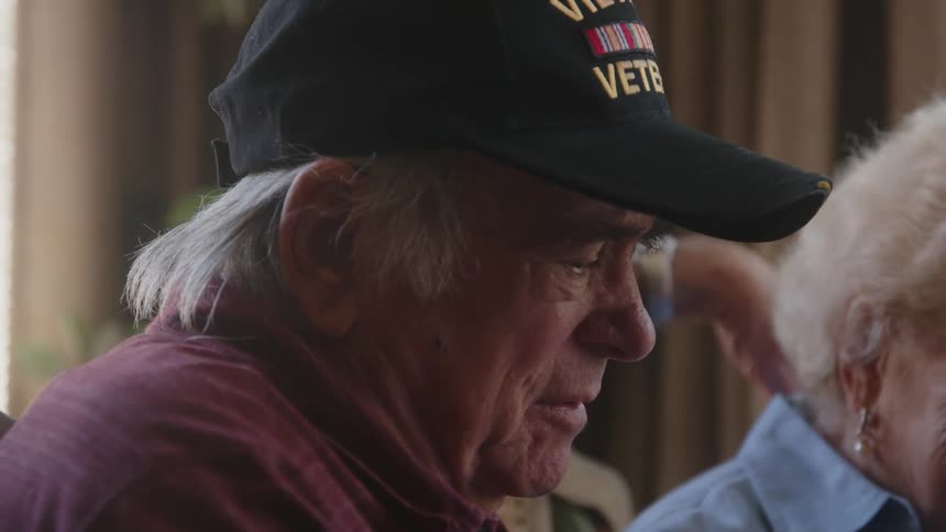 Close up of an elderly couple having a conversation at home looking at a photo album