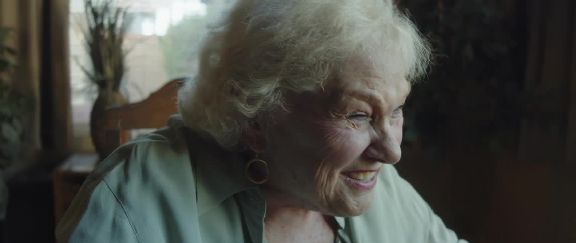 Elderly woman sitting talking and smiling