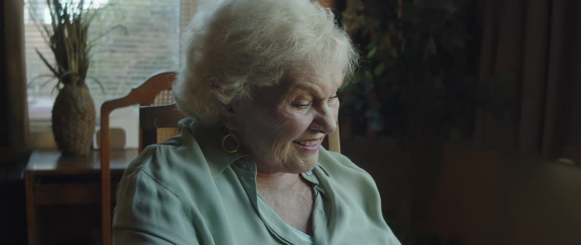 Portrait of an elderly lady sitting smiling