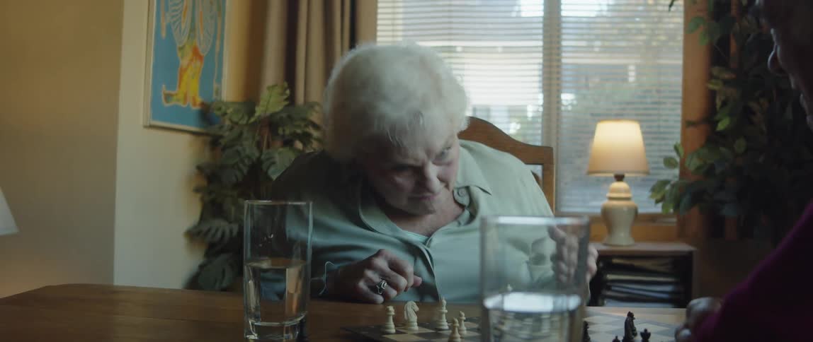 A happy elderly couple have fun telling stories to each other at home