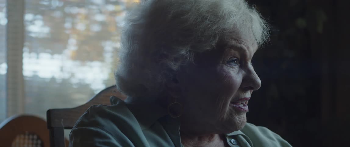 Elderly lady sitting on a chair talking and laughing