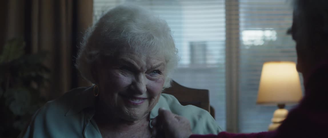 Elderly man passing his hand over his smiling wifes face