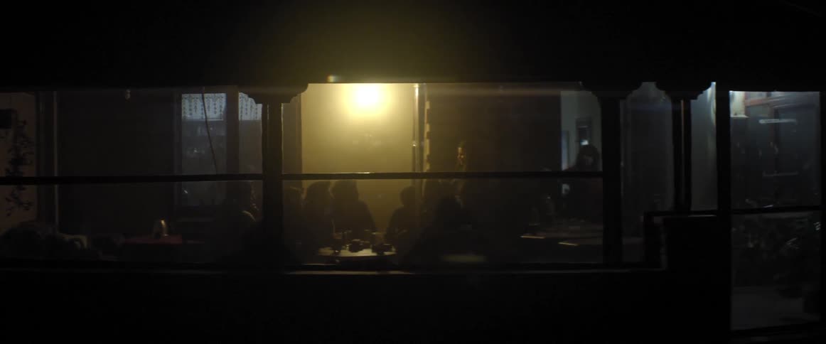 A woman hands out papers in a meeting, through a window