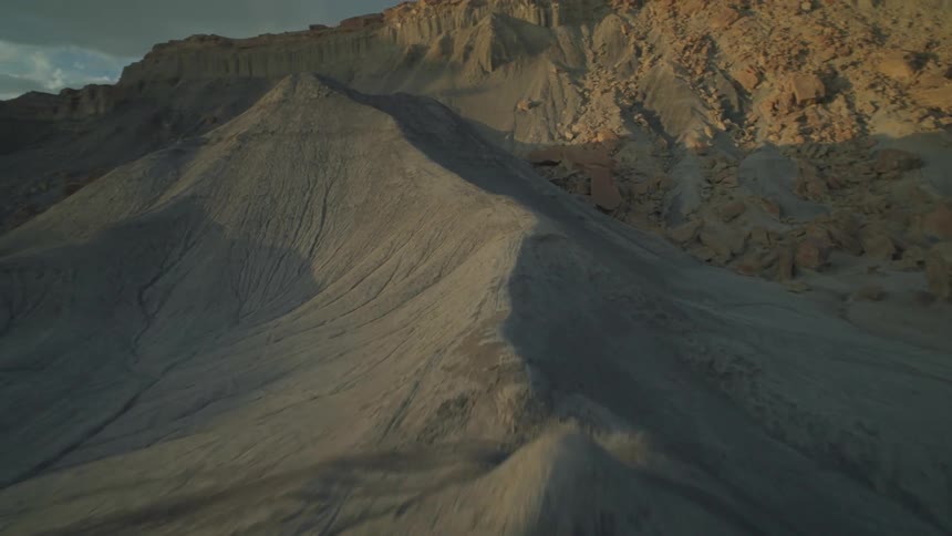 A barren landscape with layered rock formations and striations