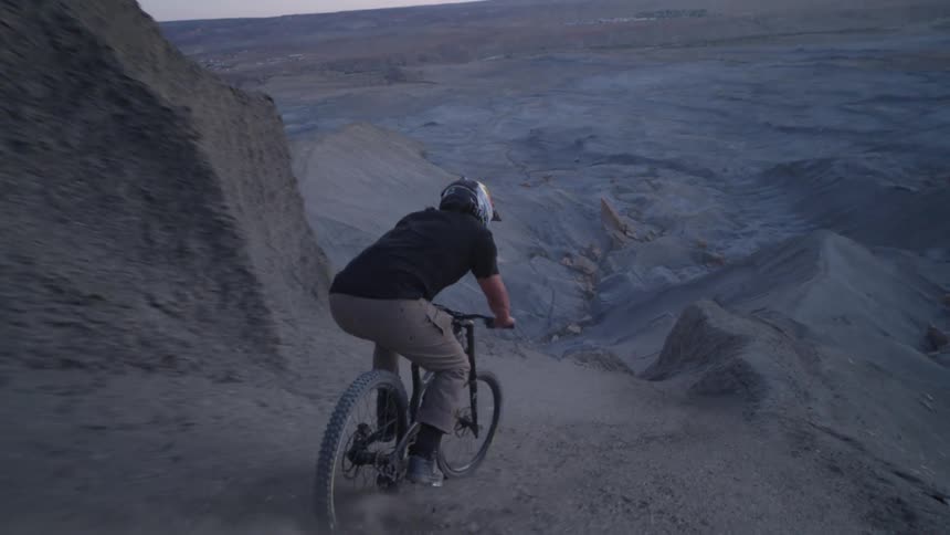 Man with helmet descending a mountain slope on a mountain bike