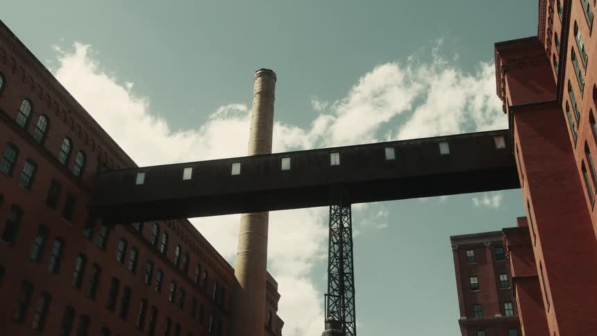 Urban and commercial buildings with a large chimney and tower in the background