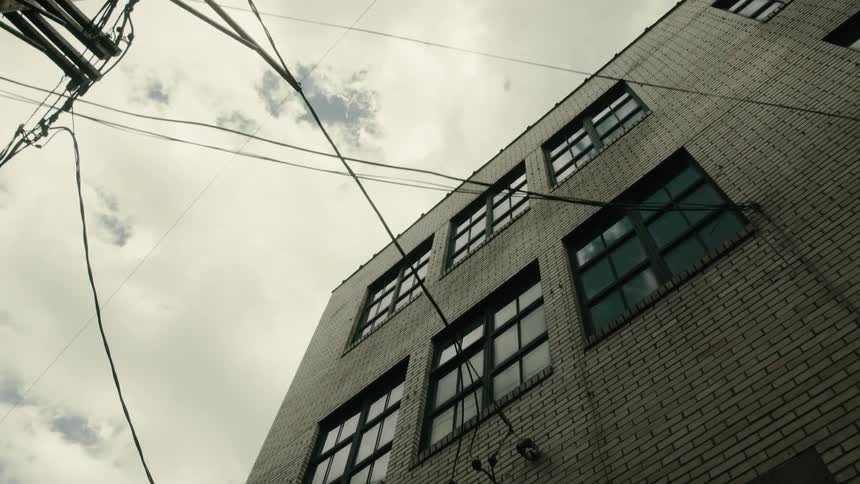 Upward view of buildings with patterned windows in a cloudy sky