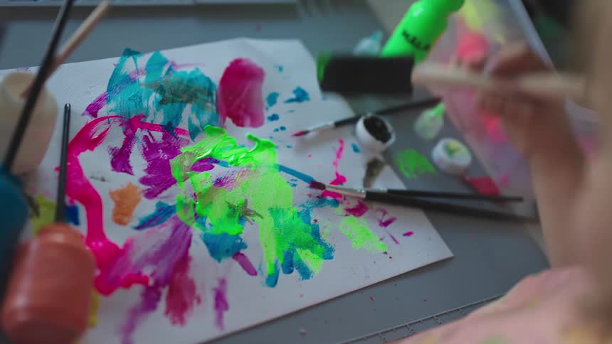 Little childs hand painting a white sheet