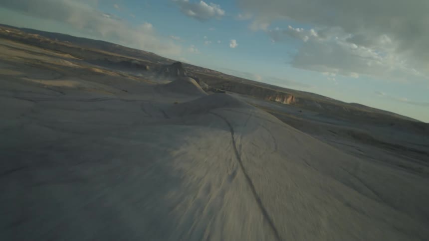 Small hills covered in track marks near a mountain range