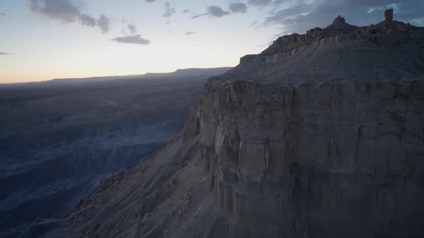 A giant mountain with steep cliffs towers over the surrounding area