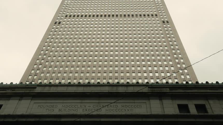 Upward view of a skyscraper against a cloudy sky