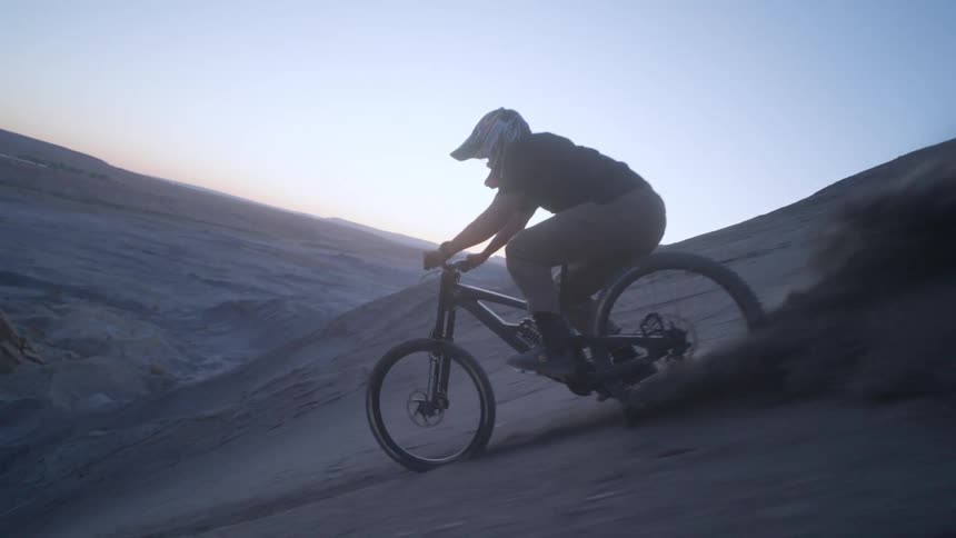 A man rides a bicycle down the side of a steep mountain