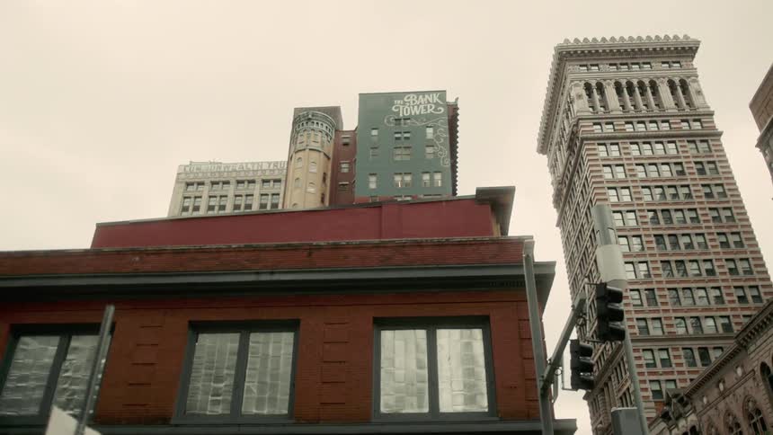 A red brick building with tall residential towers in the city