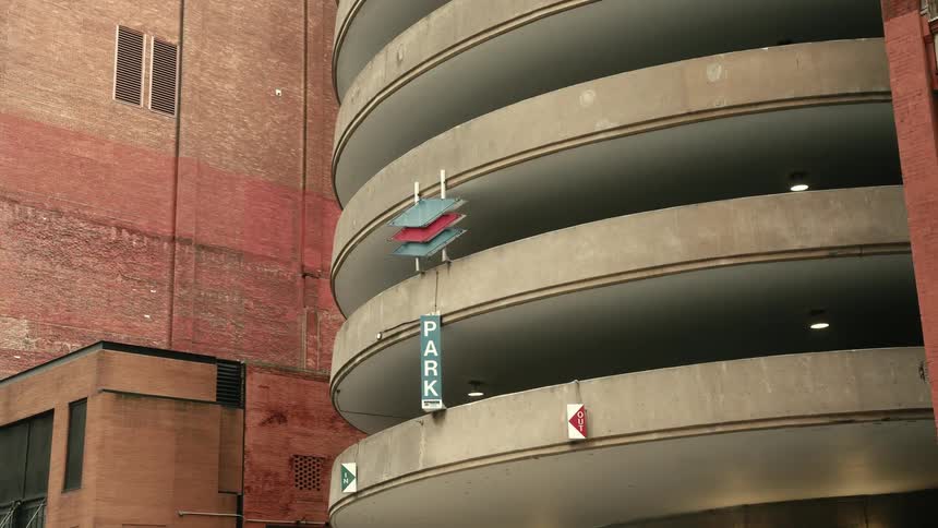 Circular parking garage stands between two red brick buildings