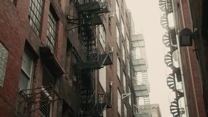 A downtown alleyway view of several apartment buildings in a metropolitan area