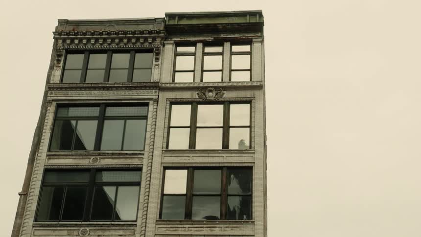 Brownstones reflecting sunlight on a gray day