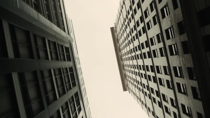 Upward view of two tall buildings with a cloudy sky in the background