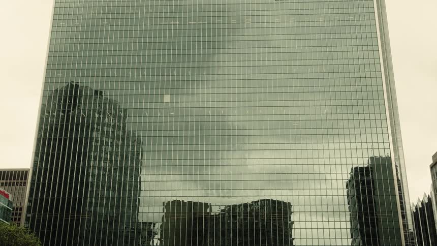 Panorama of a modern mirrored skyscraper that reflects other buildings around it