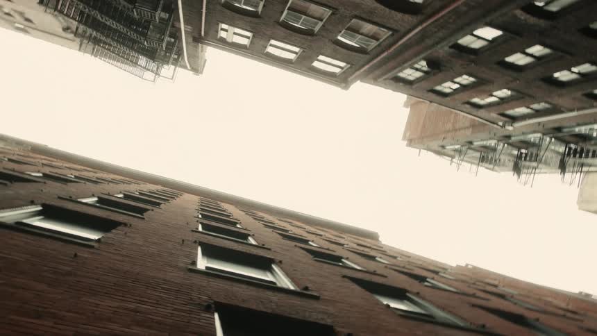 Upward view of urban tall buildings with a cloudy sky