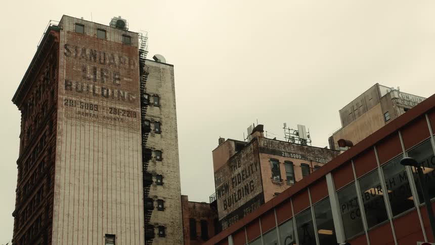 Upward view of urban and commercial buildings against a cloudy sky