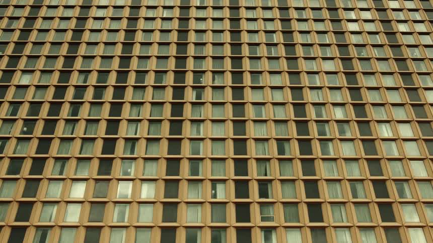 Large building with many windows some of which are lit up and some of which are dark