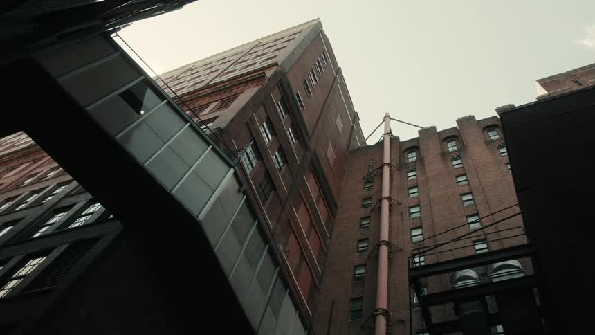 An elevated walkway connects apartment buildings in a city