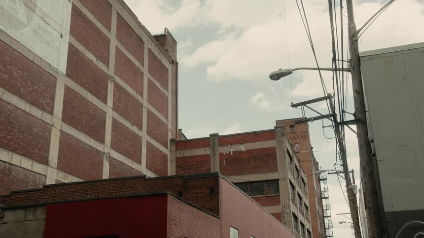 Urban buildings under construction in an alley against a cloudy sky