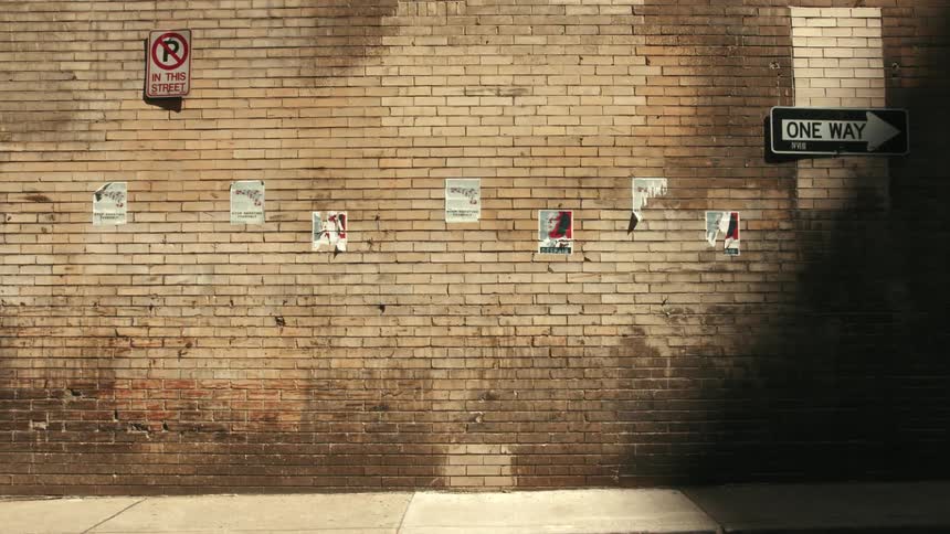 Wall of a building in an alley with a vehicle passing by