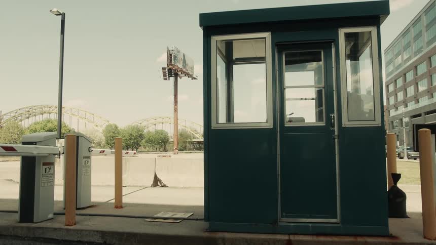 Blue security booth with glass windows in an empty parking lot