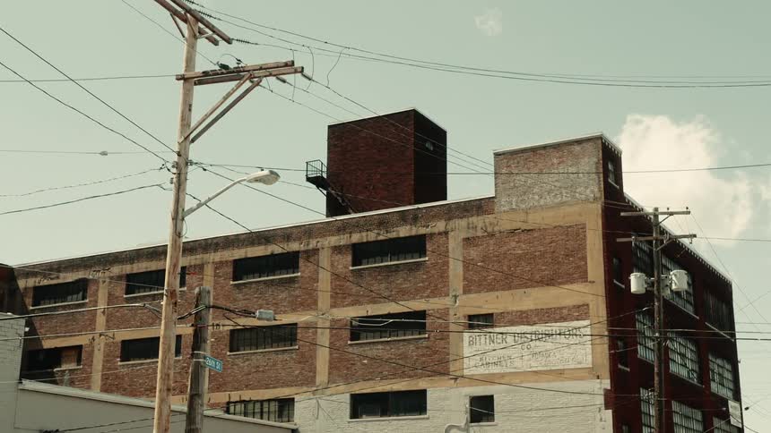 Urban buildings with lamp posts and wiring against a partly cloudy sky