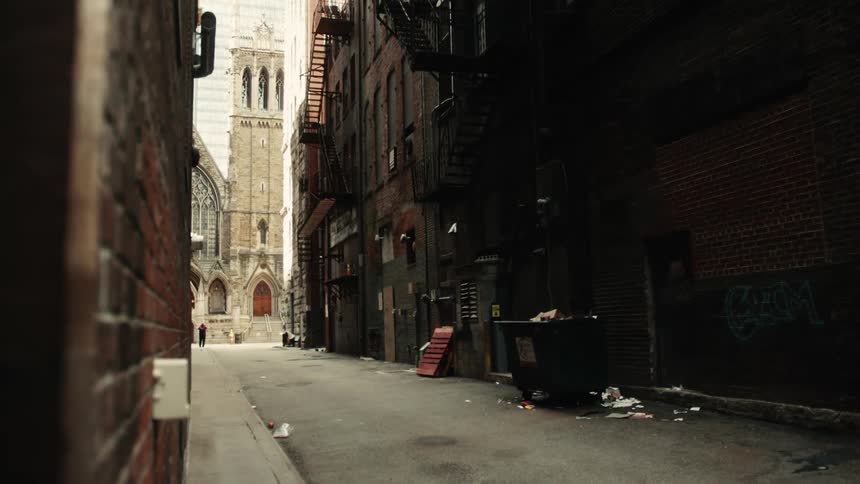 Trash in an alleyway leading to a large church