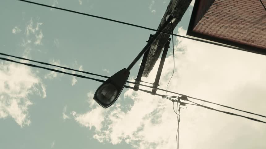 Upward view of a lamppost against a partly cloudy sky