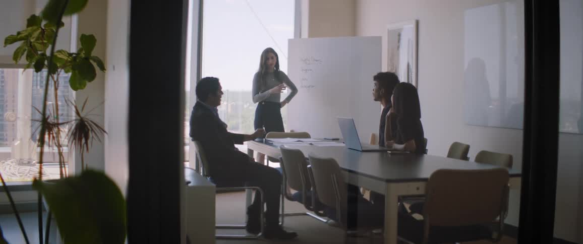Coworkers hold meeting in office conference room overlooking city