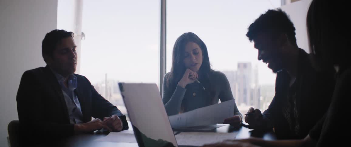 Woman takes minutes during conference about documents in office meeting room