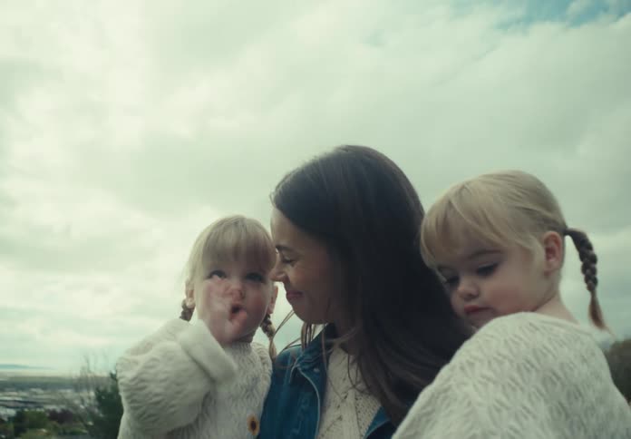 A mother carries her daughters on the field