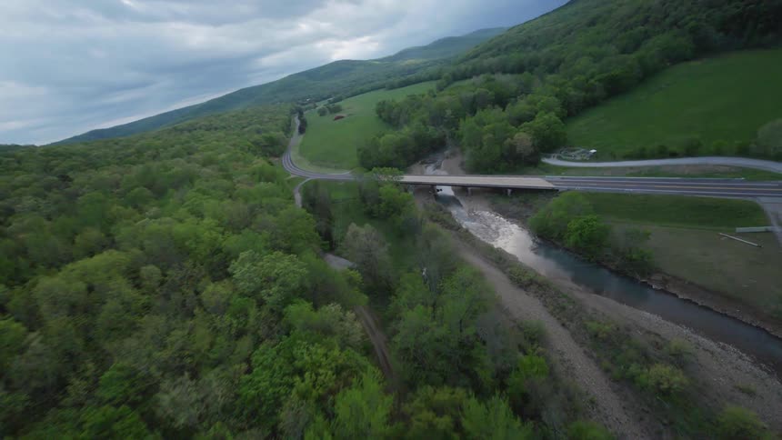 An aerial view of a forest landscape with a long road running through it in rural Arkansas