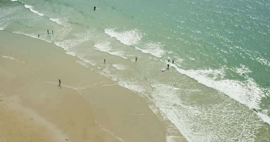 People walk into the surf to swim or surf