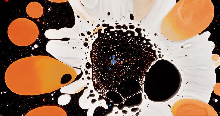 Abstract microscopic view of a droplet of colored liquid drying and generating abstract patterns against a black background